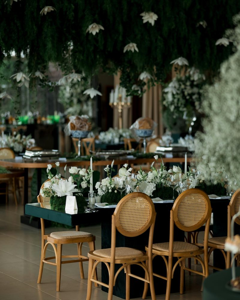 Banquet tables styled with hanging foliage and white florals at a destination event